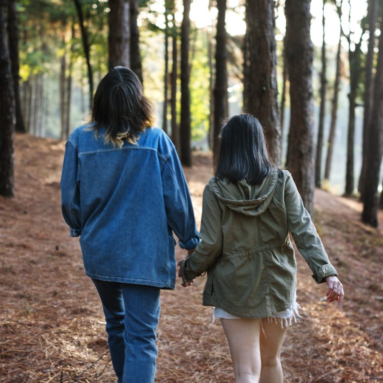 two people hold hands walking through forest 2026 03 18 11 06 24 utc